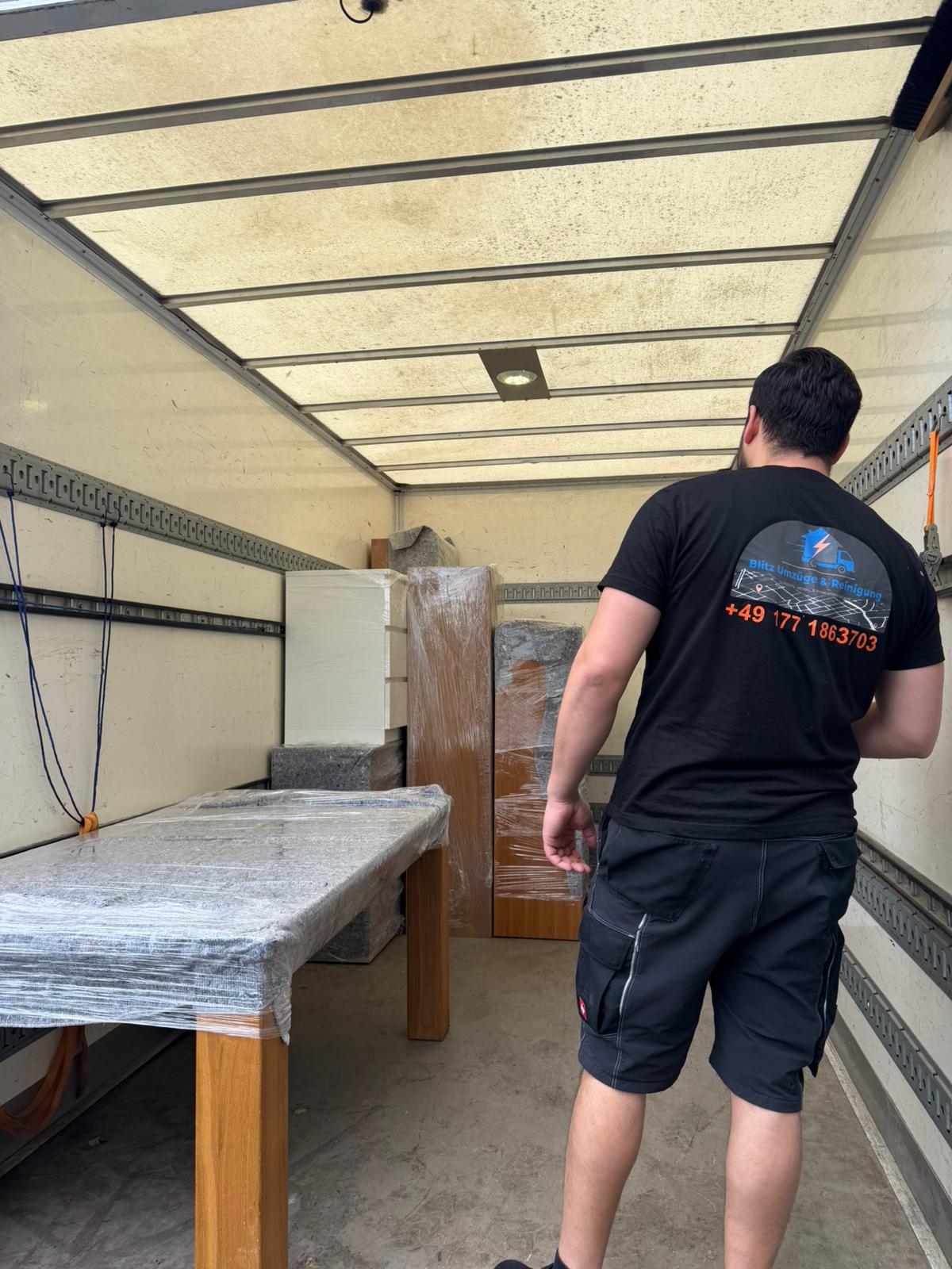Mitarbeiter von Blitz Umzüge & Reinigung beim Verladen verpackter Möbel