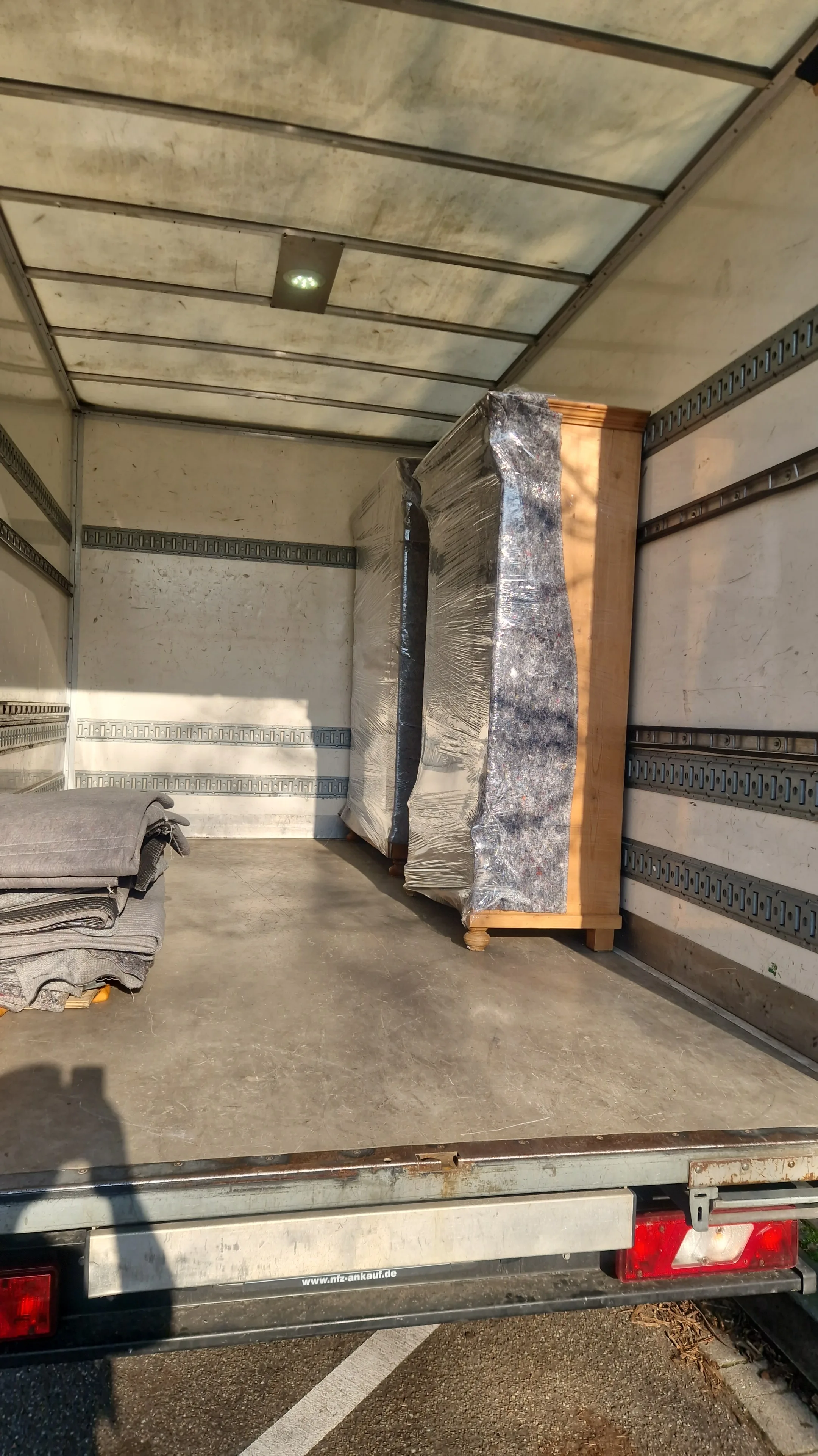 Verpackte Möbelstücke im Innenraum eines Umzugswagens